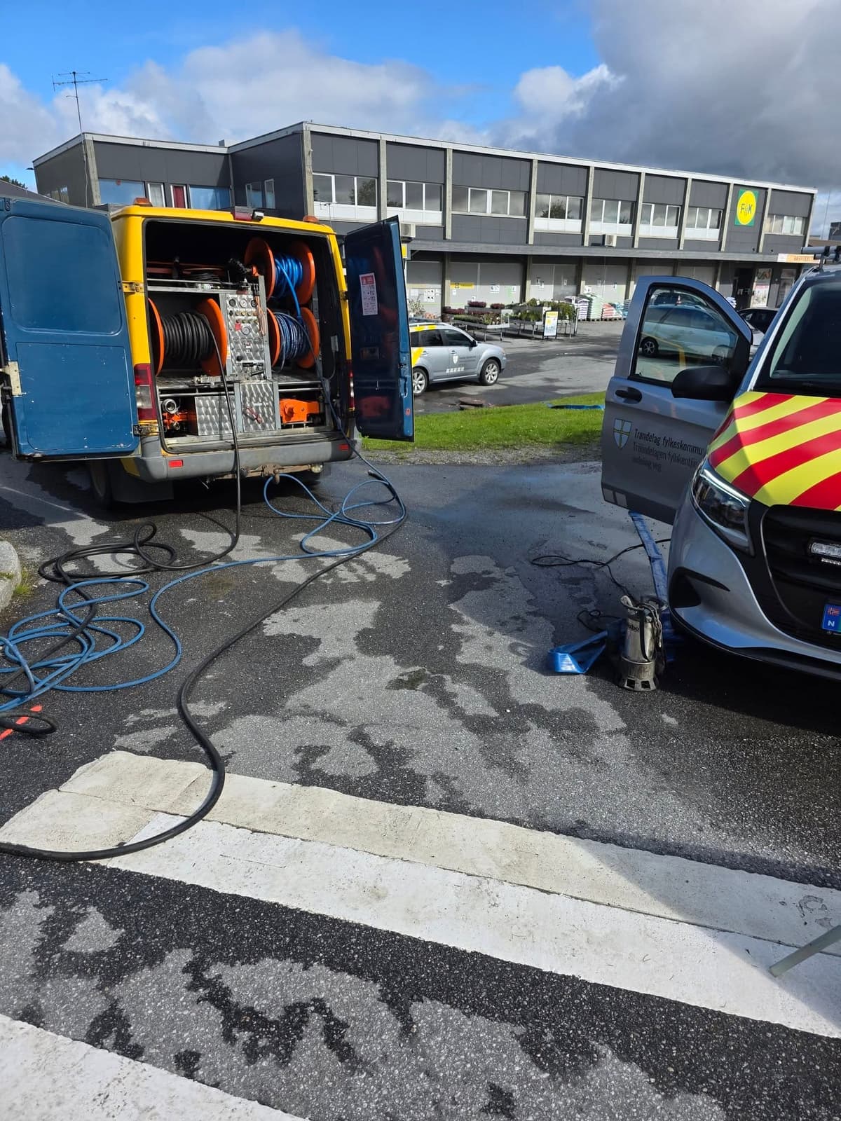 Spyleslanger lagt ut over asfalten mellom bilene på et oppdrag